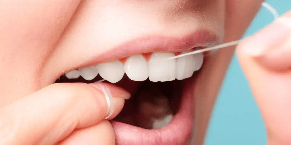 person flossing between teeth